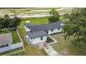 Aerial view of the home with fresh exterior paint, a well-manicured yard, and a private driveway at 609 Brockway Ave, Orlando, FL 32807