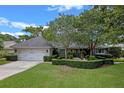 Charming single-story home with lush landscaping, mature trees, and a two-car garage at 641 Virginia Dr, Winter Park, FL 32789