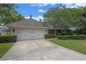 Home exterior featuring a well-manicured lawn, mature trees, and a two-car garage at 641 Virginia Dr, Winter Park, FL 32789