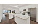 Bright open concept kitchen with stainless appliances, central island, and adjacent living area at 6931 Sperone St, Orlando, FL 32819