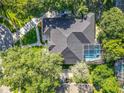 Aerial view of a beautiful house featuring a screened-in pool and a manicured lawn at 704 Forest View Ct, Winter Springs, FL 32708