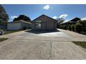 Well-kept single-story house showcasing a two-car garage, a driveway, and low maintenance landscaping at 8258 Golden Chickasaw Cir, Orlando, FL 32825