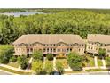Aerial view of a townhouse complex with a beautiful lake and green space in the background at 9997 Town Lake Dr, Orlando, FL 32832