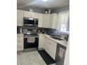 Efficient kitchen with white cabinets, stainless appliances, and ample counter space, perfect for cooking at 1034 Villa Ln # 18, Apopka, FL 32712