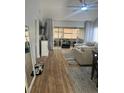Bright living room with wood floors, neutral walls, ceiling fan, and glass doors to Florida room at 1034 Villa Ln # 18, Apopka, FL 32712