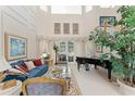 Bright living room with large windows, a grand piano, and elegant decor at 10915 Emerald Chase Dr, Orlando, FL 32836