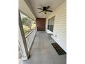 Inviting covered front porch featuring a ceiling fan, swing, and a 'Welcome' mat at 1140 Odoniel S Loop, Lakeland, FL 33809