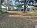 Spacious front yard with mature trees surrounding a well-kept single-story brick home at 1140 Odoniel S Loop, Lakeland, FL 33809