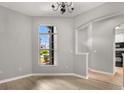 Bright dining room featuring a large window, chandelier, and hardwood floors at 13658 Hidden Forest Cir, Orlando, FL 32828