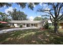 Inviting home with mature trees, a well-manicured lawn, and a quaint covered entryway at 1481 Glastonberry Rd, Maitland, FL 32751