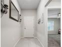 Inviting hallway with neutral tones, tiled floors, and access to various rooms in the home at 220 Foxtail Loop, Davenport, FL 33837