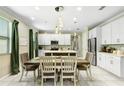 Bright dining area featuring a modern chandelier and views of the updated kitchen at 2491 Wadeview Loop, St Cloud, FL 34769