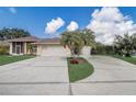 Long driveway leading to a two-car garage, adorned with palm trees, and a small storage shed at 2800 Woodsmere Ct, Kissimmee, FL 34746