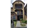 Exterior of tan apartment building with dark brown trim, balconies and brick accent with landscaping at 420 Forestway Cir # 202, Altamonte Springs, FL 32701