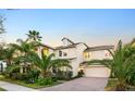 Elegant two-story home with brick driveway and tropical landscaping at 5552 Remsen Cay Ln, Windermere, FL 34786