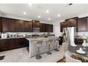 Modern kitchen featuring dark wood cabinetry, stainless steel appliances, and an island with bar seating at 5846 Sw 80Th Ln, Ocala, FL 34476