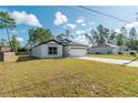 Inviting home with white exterior, dark accents, a long driveway, and well-manicured lawn at 6291 Sw 133Rd Street Road, Ocala, FL 34473