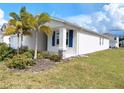 Side view of a charming single-Gathering home with blue shutters and tropical landscaping at 6300 Chirpine Ln, St Cloud, FL 34771