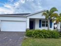 Charming single-Gathering home with a two-car garage, brick paver driveway and tropical landscaping at 6300 Chirpine Ln, St Cloud, FL 34771