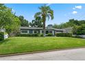 Single-story home with a large green lawn and a mature palm tree, enhancing the property's tropical feel at 811 Oregon St, Orlando, FL 32803