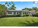 Inviting single-story home with a lush green lawn, trimmed hedges, and an American flag adding a patriotic touch at 811 Oregon St, Orlando, FL 32803