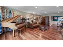 Spacious living room with gleaming hardwood floors, a grand piano, and a comfortable leather sofa at 811 Oregon St, Orlando, FL 32803