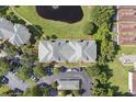 Overhead view shows a meticulously kept apartment complex, landscaped with a beautiful pond and surrounding trees at 8816 Dunes Ct # 303, Kissimmee, FL 34747
