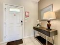 Welcoming entryway featuring tile flooring, a console table with decor, and a bright front door at 8911 Geneve Ct, Kissimmee, FL 34747