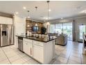 Modern kitchen with stainless steel appliances, a central island, and seamless access to the living area at 8911 Geneve Ct, Kissimmee, FL 34747