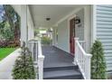 Spacious front porch with white railings, a red entry door, and a stylish address number at 1021 S Elm Ave, Sanford, FL 32771