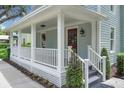 Close-up of a charming front porch with white columns, a red door, and address number 1021 at 1021 S Elm Ave, Sanford, FL 32771