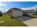 Side view of a single-Gathering home showcasing the driveway and two-car garage at 1105 Citrus Landings Blvd, Davenport, FL 33837