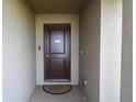 Close-up of a brown front door with a 'No Soliciting' sign and welcome mat at 1105 Citrus Landings Blvd, Davenport, FL 33837