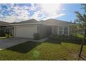 Inviting single-Gathering home with green lawn, complemented by a two-car garage at 1105 Citrus Landings Blvd, Davenport, FL 33837
