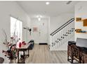 Bright entryway with laminate flooring, a staircase, and a white front door at 12347 Ne 52Nd Loop, Oxford, FL 34484