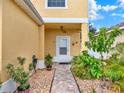 Charming front entrance with a tiled walkway, complemented by vibrant plants and stone landscaping at 12347 Ne 52Nd Loop, Oxford, FL 34484