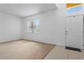 Bright living room featuring neutral carpet, large window, and a white front door at 1457 Teal Dr, Kissimmee, FL 34759