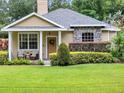 A cozy front porch with classic columns and matching chairs create a welcoming entry at 2009 E Grant St, Orlando, FL 32806
