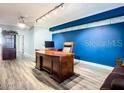 Office features a large desk, blue accent wall, and laminate wood floors at 2055 S Atlantic Ave # 505, Daytona Beach, FL 32118