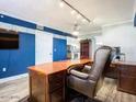 Office features a large desk, blue accent wall, laminate wood floors, and white trim at 2055 S Atlantic Ave # 505, Daytona Beach, FL 32118