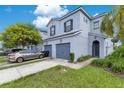 Light blue two story townhouse with a two car garage, concrete driveway and manicured lawn at 20610 Maxim Pkwy, Orlando, FL 32833