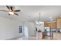 Open floor plan showcasing kitchen with stainless steel appliances, breakfast bar, and a modern hanging light fixture at 20610 Maxim Pkwy, Orlando, FL 32833