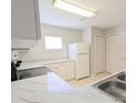 Bright eat-in kitchen with white cabinets, countertops, appliances, and a stainless-steel sink at 2816 Club Cortile Cir # A, Kissimmee, FL 34746