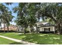 Beautiful home exterior featuring manicured lawn, mature trees, and a sidewalk leading to the front entrance at 2890 Wild Ginger Ct, Winter Park, FL 32792
