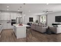 Bright, open floor plan with modern kitchen featuring a center island and sleek stainless steel appliances at 3492 Lemon Button Ter, Apopka, FL 32712