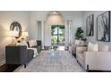 Bright living room with modern decor, a decorative mirror, neutral furniture, and a view of the lake at 3531 Oriskany Dr, Orlando, FL 32820