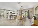 Bright dining area with modern lighting, a view to the backyard, and an adjacent kitchen space at 3531 Reston Dr, The Villages, FL 32162