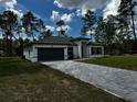 Lovely one-story home featuring a gray driveway, black trim, and a well-kept lawn at 5119 Sw 165Th Pl, Ocala, FL 34473