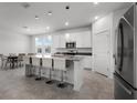 Bright and airy kitchen with stainless steel appliances, white cabinets, gray counters, and an island bar with seating at 6458 Pine Warbler Way, St Cloud, FL 34771