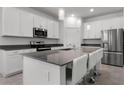 Modern kitchen featuring stainless steel appliances, white cabinets, gray countertops, and a large island with seating at 6458 Pine Warbler Way, St Cloud, FL 34771